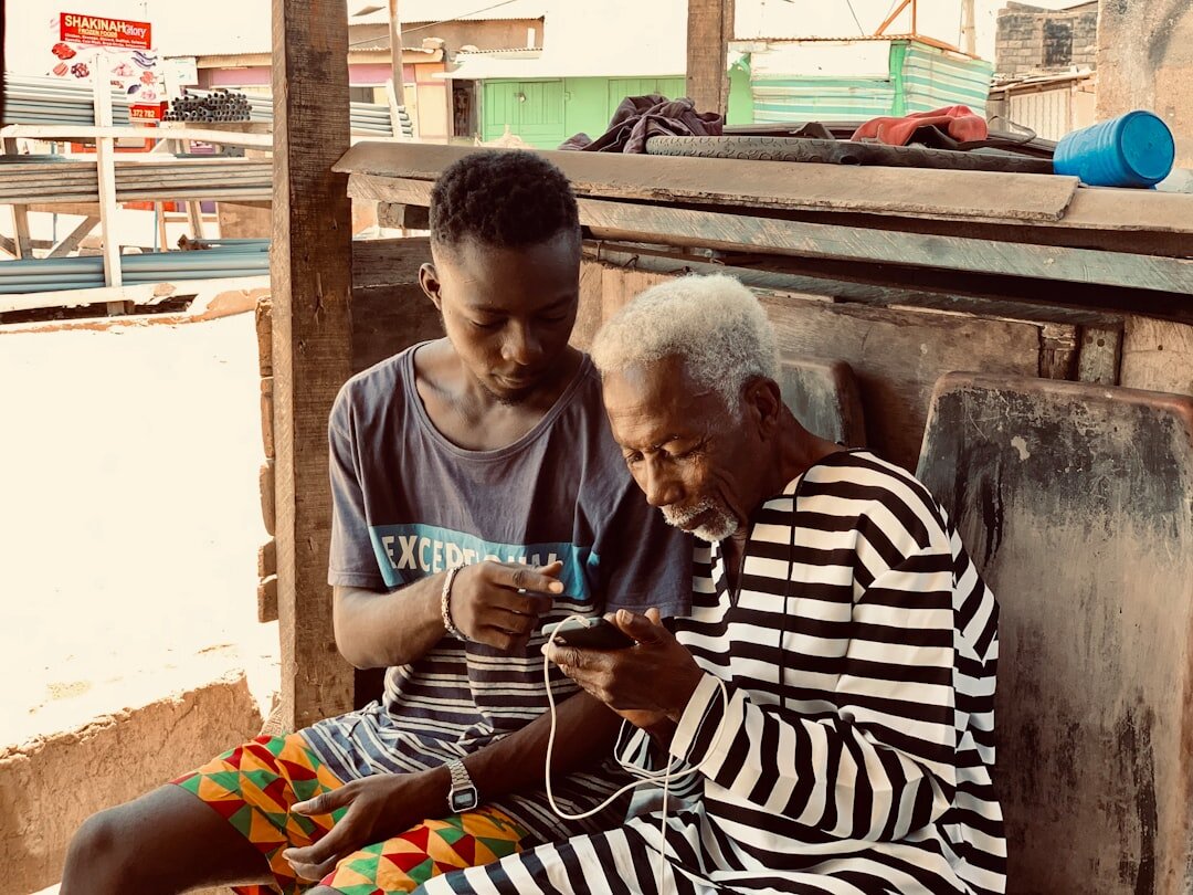Senior woman learning to use a smartphone with help from a grandchild